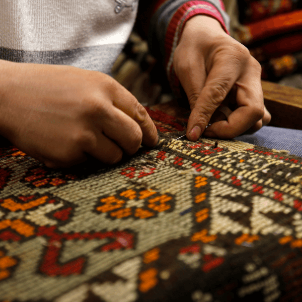 Hands knotting rug